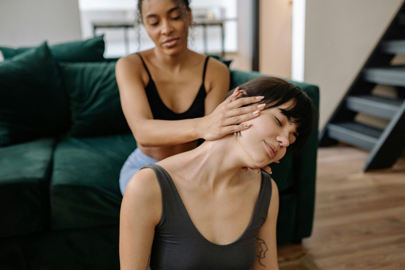 Two women enjoying a relaxing neck massage session indoors, promoting health and friendship.